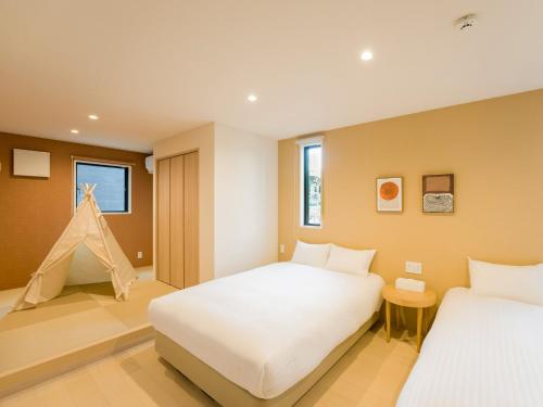 1 dormitorio con 2 camas y una tienda de juegos en Rakuten STAY VILLA Yatsugatake - 103 Family Room Pets Friendly -, en Hokuto
