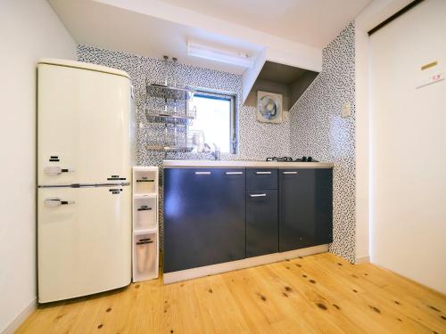 a kitchen with a white refrigerator and a wooden floor at Kokoyui Guest House Shingu - Vacation STAY 03207v in Shingu