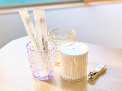 a table with two glass vases and a candle at Kokoyui Guest House Shingu - Vacation STAY 03207v in Shingu