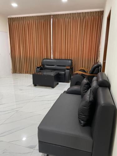 a living room with a couch and two chairs at Hotel Asia Express in Lembang