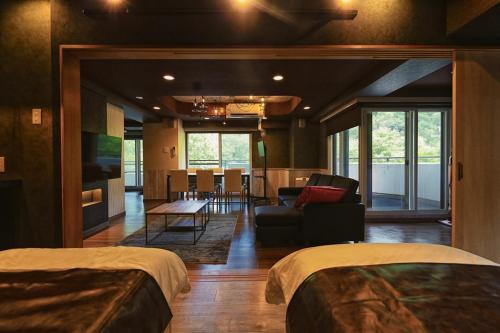 ein Hotelzimmer mit zwei Betten und einem Esszimmer in der Unterkunft Lions Mansion Sapporo Jozankei Sanbankan Room 201 - Vacation STAY 14335 in Jozankei
