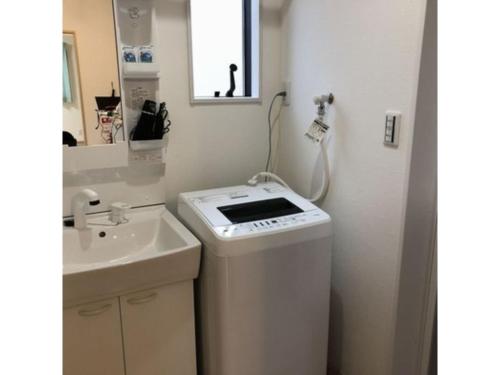 un piccolo bagno con lavandino e lavatrice di Sunset Village - Vacation STAY 15314v a Onomichi