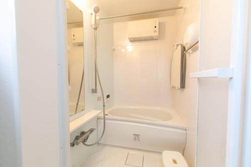 a bathroom with a tub and a sink and a toilet at Nosecho Guest House - Vacation STAY 14366 in Kawabe