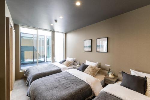 a bedroom with three beds and a couch at nabe cape - Vacation STAY 04217v in Tagawa