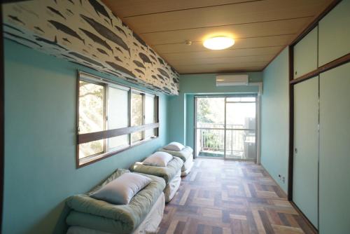 a row of couches in a room with windows at Izu Shirahama Taiyo Mansion - Vacation STAY 04444v in Shimoda