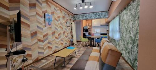 a living room with a couch and a tv and a wall at Izu Shirahama Taiyo Mansion - Vacation STAY 04444v in Shimoda