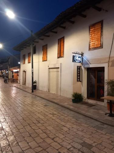 an empty street at night with a white building at Rooms for Rent in Shkodër