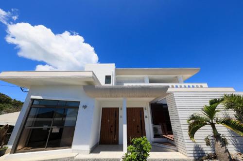 a white house with a blue sky at Harbor front JIRAMA 1 - Vacation STAY 14658 in Suno