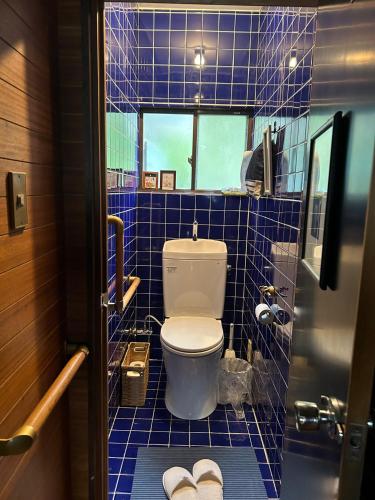 a bathroom with a toilet and blue tiled walls at Tenya - Vacation STAY 34204v in Kami Amakusa