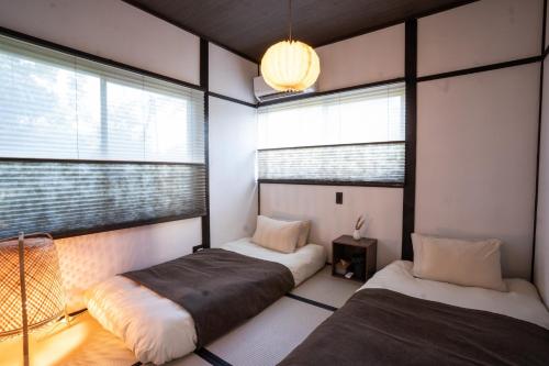 zwei Betten in einem Zimmer mit zwei Fenstern in der Unterkunft simanoyadoya - Vacation STAY 85202v in Awaji