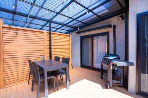 eine Terrasse mit einem Tisch, Stühlen und einem Grill in der Unterkunft simanoyadoya - Vacation STAY 85202v in Awaji