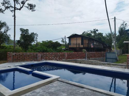 a swimming pool with a house in the background at MyDusun Chalet, Taiping, Perak, Malaysia in Taiping