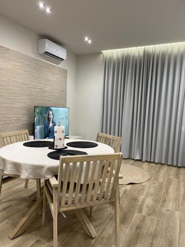 a dining room with a table with a laptop on it at SanPietro Premium 224 in Lalzit Bay