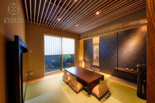 a dining room with a wooden table and a window at Seseragi-an Sakura - Vacation STAY 44821v in Kyoto