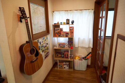 a guitar hanging on a wall in a room at Sunland S45 - Vacation STAY 45835v in Saikubo