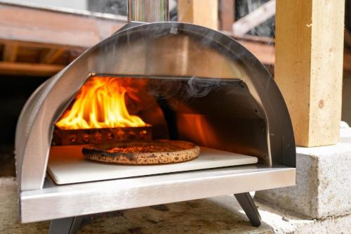 a pizza oven with two pizzas cooking in it at Sunland S45 - Vacation STAY 45835v in Saikubo