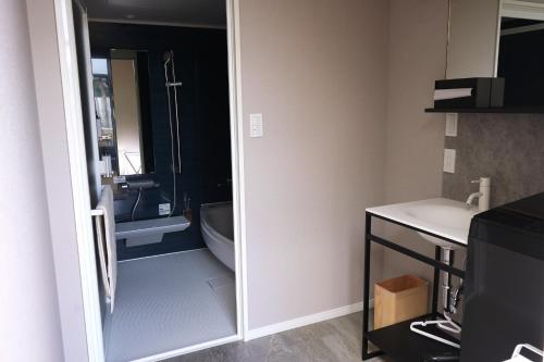 a bathroom with a tub and a sink and a toilet at Etcetera Niijima Jessica Building - Vacation STAY 74384v in Niijimamura