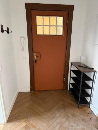 an orange door in a room with a wooden floor at Villa Rathenow in Rathenow
