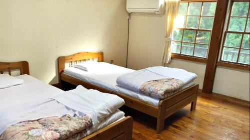 two twin beds in a room with two windows at Tabino Camping Base Kami Yuland - Vacation STAY 52575v in Osaki
