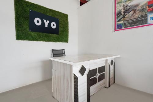 a table in a room with a sign on a wall at SPOT ON The Cocoon Palace in Sarāi Ajitmal