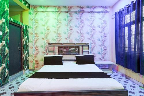 a bedroom with a large bed in a room with wallpaper at SPOT ON The Cocoon Palace in Sarāi Ajitmal