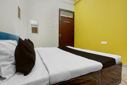 a bedroom with a bed with a black pillow on it at SPOT ON Rajshree Homestay Varanasi in Varanasi