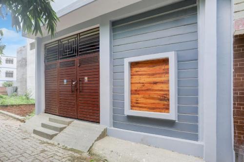 a house with a wooden door and a window at SPOT ON Rajshree Homestay Varanasi in Varanasi