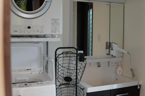 a kitchen with a sink and a microwave at Kikunoko 3 Can Villa & Terrace C Building - Vacation STAY 50396v in Miyako Island