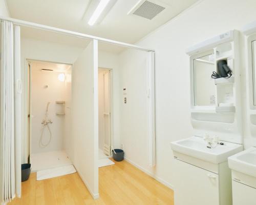 un bagno bianco con lavandino e specchio di Kinoene SAKE CAMP - Camp - Vacation STAY 42048v a Shisui