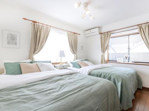 deux lits dans une chambre avec une fenêtre dans l'établissement Lana Enoshima - Vacation STAY 56484v, à Fujisawa