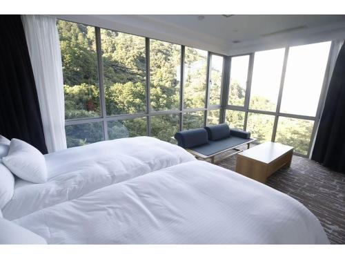 a bedroom with a white bed and a large window at Atami Spa & Resort - Vacation STAY 14644 in Atami