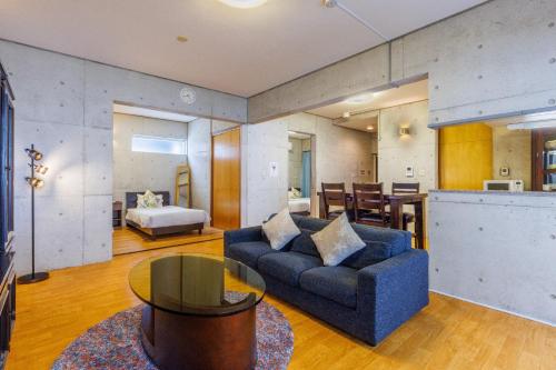 a living room with a blue couch and a table at New Life Mansion 101 - Vacation STAY 57160v in Fuzuchi