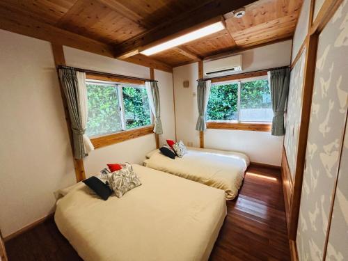 two beds in a room with two windows at Private Villa - Vacation STAY 36268v in Sesoko