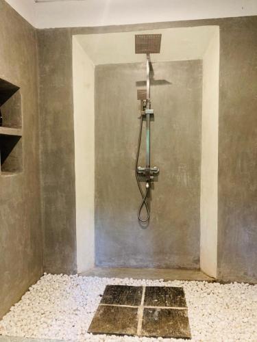 a shower in a room with a wall at Coco Breeze Villa in Talpe