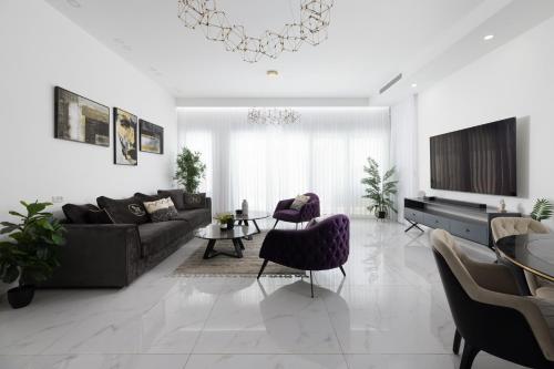 ein Wohnzimmer mit Couch und Stühlen in der Unterkunft ים סוף - דירת גן מושלמת עם בריכה פרטית למשפחות באילת in Eilat