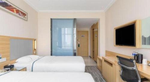 a hotel room with two beds and a desk at City Comfort Inn Beihai RT-Mart High Speed Railway Station in Beihai