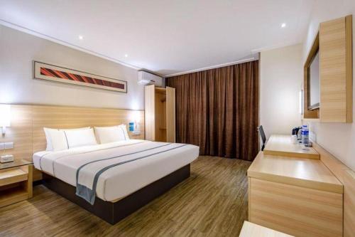 a hotel room with a bed and a desk at City Comfort Inn Beihai RT-Mart High Speed Railway Station in Beihai