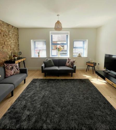 a living room with a couch and a tv at High Street Apartment in Garstang