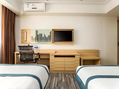 a hotel room with two beds and a desk and a tv at City Comfort Inn Zhaoqing Qixingyan Scenic Area Xinghu Archway in Zhaoqing