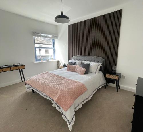 a bedroom with a large bed and a window at High Street Apartment in Garstang