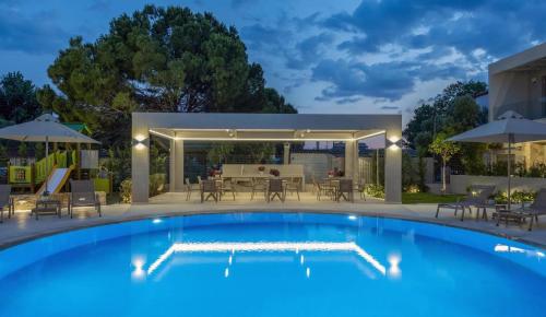 a swimming pool with a patio with a table and chairs at Darion Luxury Villa Nikiti Chalkidiki in Nikiti
