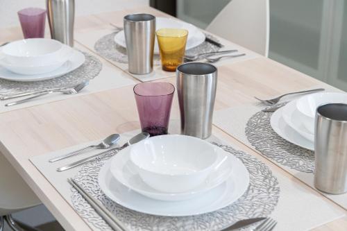 a table with white plates and silver utensils at Can Li Asso D in Minami Aso
