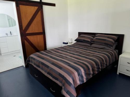 a bedroom with a large bed with a wooden door at Golf Links Sunset Cabin 