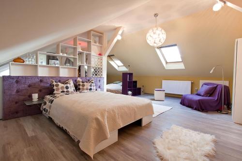 a bedroom with a large bed and a purple wall at Cluj Napoca Apartments in Cluj-Napoca