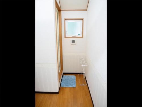a small hallway with a window and a blue rug at 森と湖の楽園ＷorkshopＣampＲesort in Fujikawaguchiko