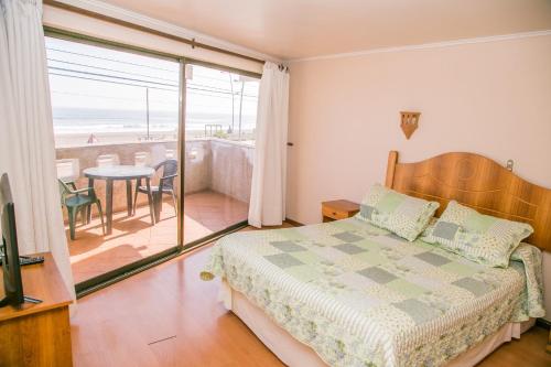 a bedroom with a bed and a view of the beach at Cabañas Las Añañucas II in La Serena