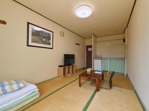 a living room with a couch and a table at Tabist Business Hotel Teramoto in Chita