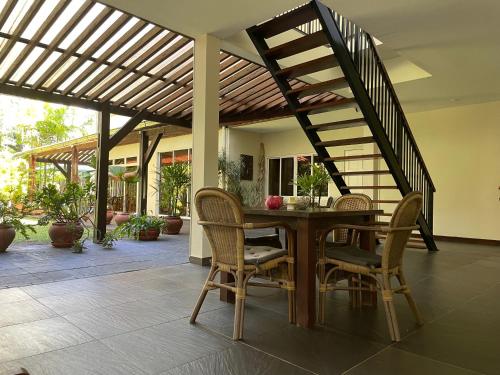 a patio with a table and chairs and a staircase at Mathurin Appartementen in Paramaribo