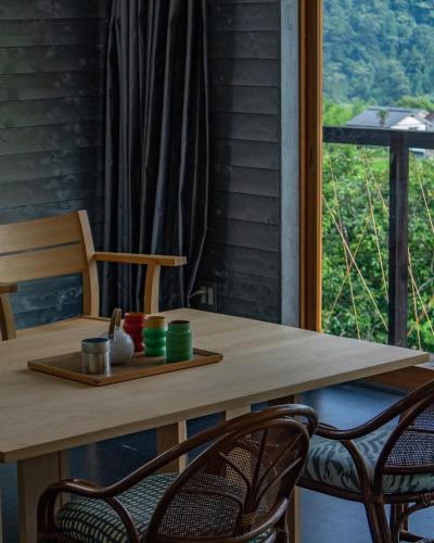 a wooden table with two chairs and a window at OKANiWA 丘庭 in Nagiso