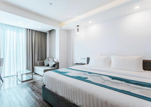 a bedroom with a large bed and a couch at Maagiri Hotel in Male City